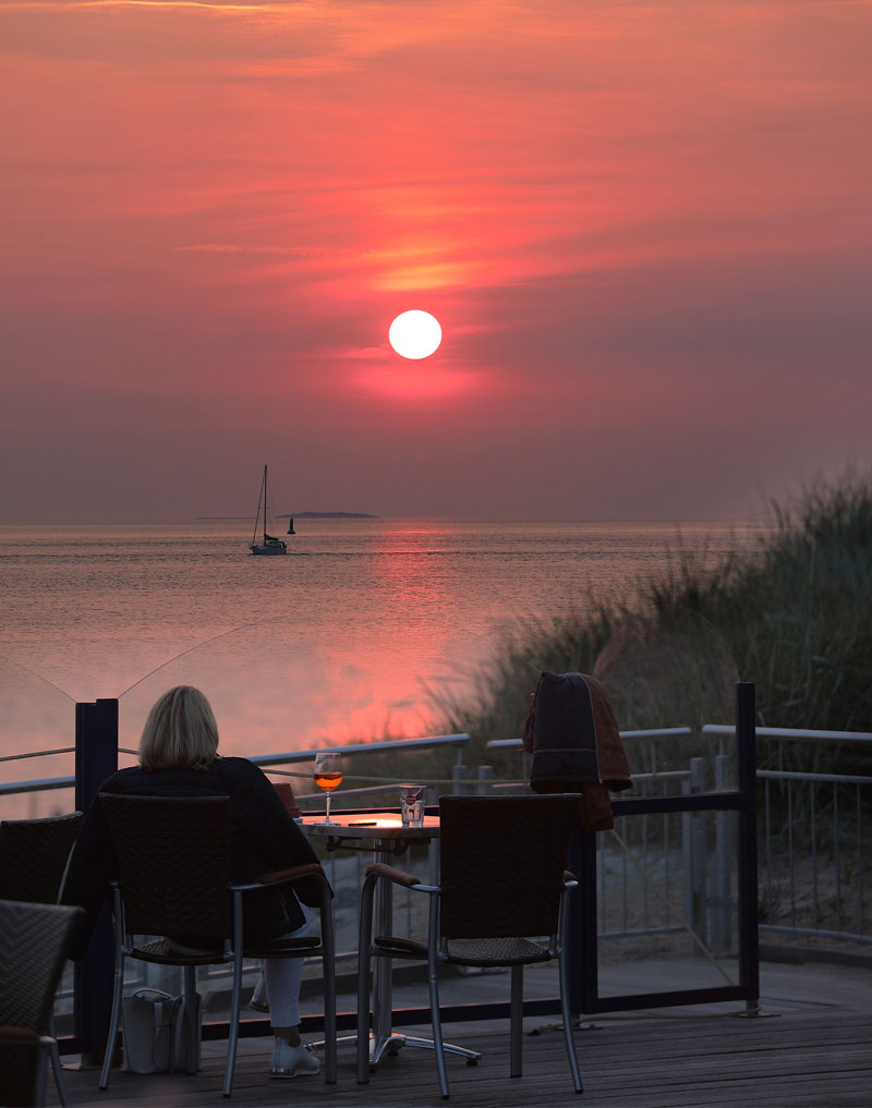 Frau trinkt Aperol Spritz im Sonnenuntergang