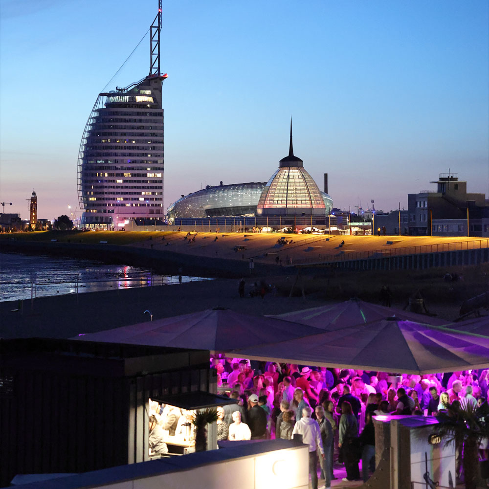 Blick auf die Terrase der Sandbank mit Party. Im Hintergrund die Havenwelten